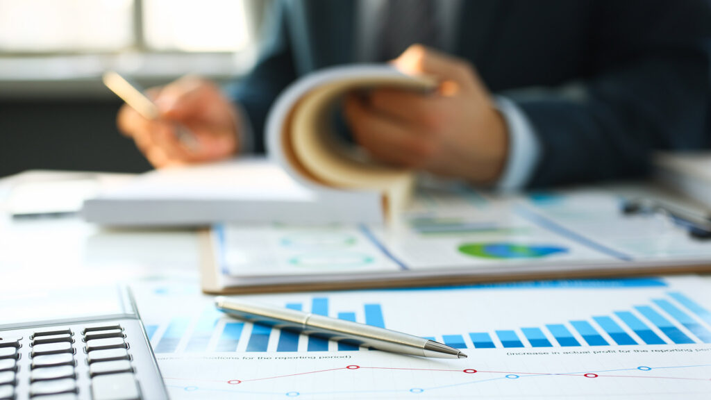 Person looking through finances with charts and calculator