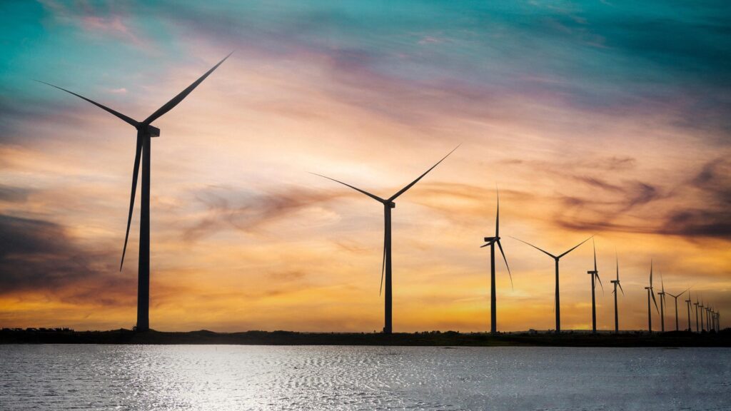 Wind farm at sunset by the water